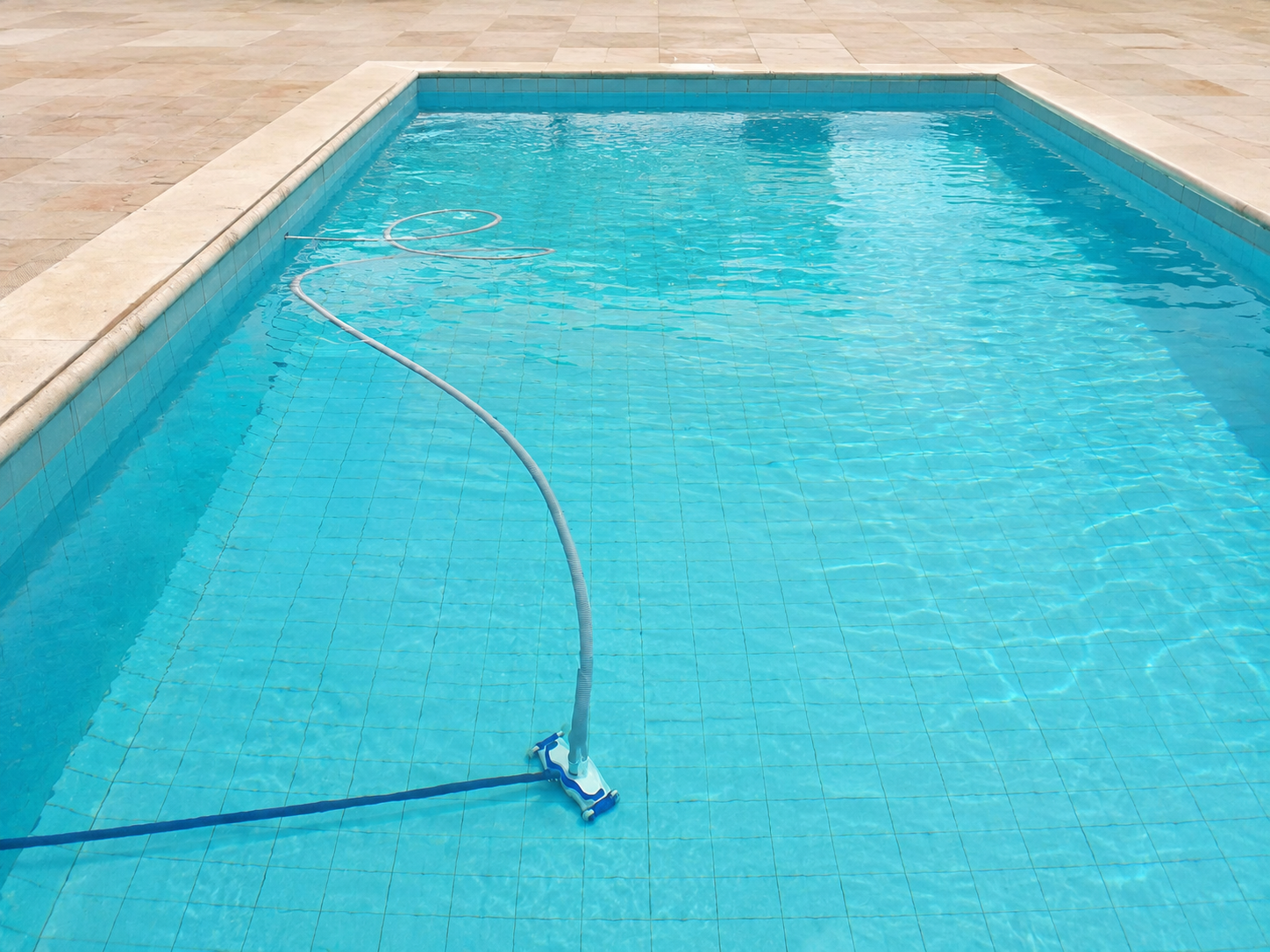 Piscina con agua limpia y barredera para su mantenimiento periódico